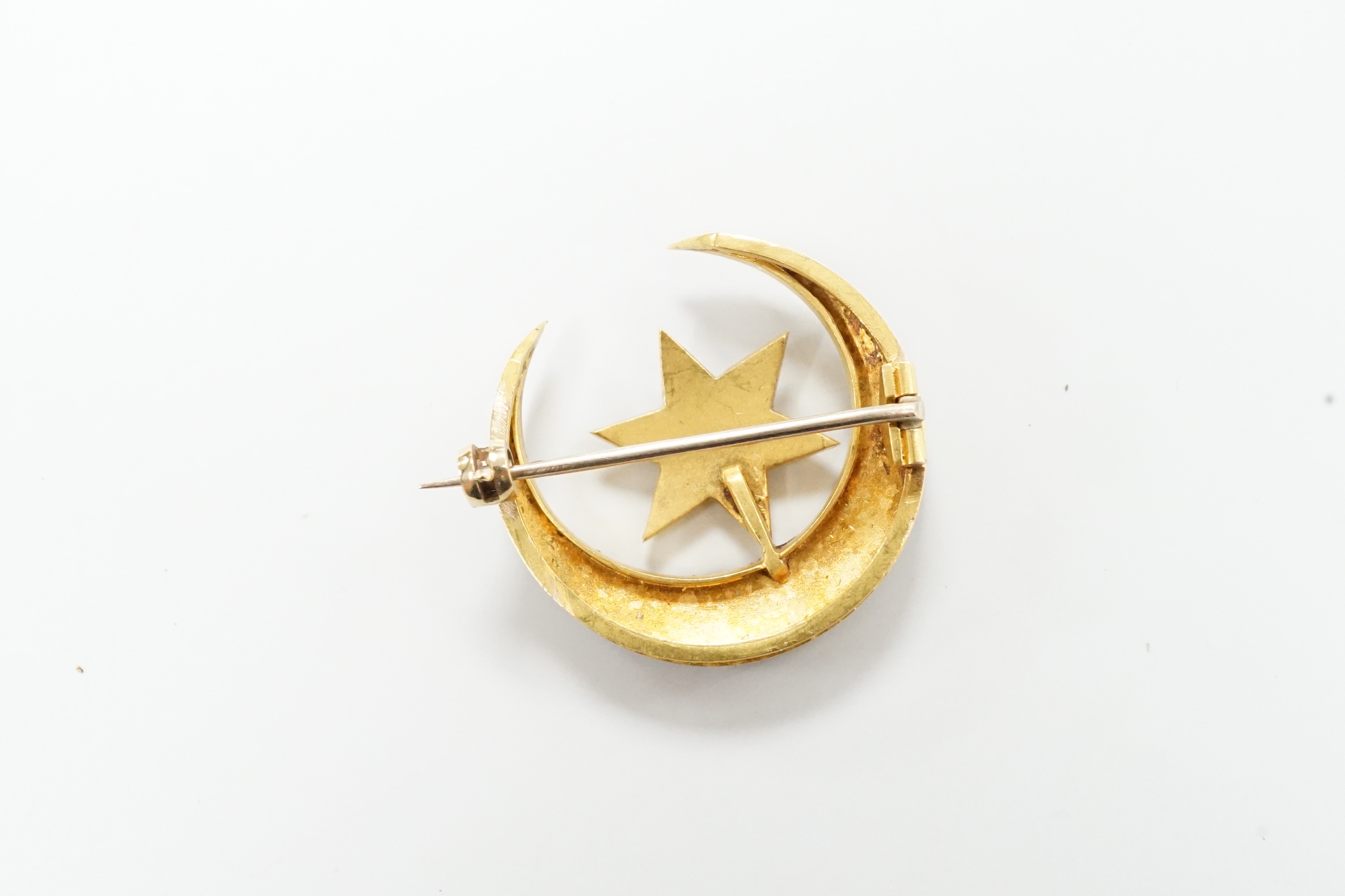 An Edwardian yellow metal and seed pearl set 'star and crescent moon' brooch, 26mm, 6.1 grams, in fitted case.